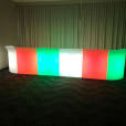 A vibrant LED bar, glowing with red, green, and blue hues, illuminating the room.