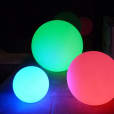 A group of 50cm colorful lighted Glow Spheres on a concrete floor.