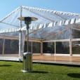 A white tent with a Mushroom Heater on the grass.