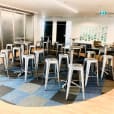 A group of Silver Tolix stools in a circular room.