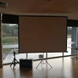 A spacious room featuring a projector screen on one side.