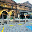 A brick building entrance with a wheelchair ramp available for hire.