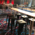 A room with White hairpin High Bar Tables and stools in it.