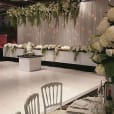 A beautiful white wedding reception set up adorned with elegant white flowers.