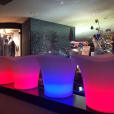 A group of lighted stools in a bar, creating a glowing ambiance.