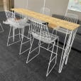 A white hairpin high bar table with timber top in an office.