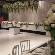 A glossy bridal wedding reception with white flowers and white tablecloths for hire.