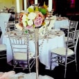 A table with silver Tiffany chairs and flowers on it.