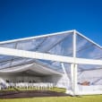 A white framed marquee tent set up on a grassy field.