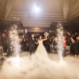 A bride and groom walk down the aisle with sparklers in the air, enhanced by a professional dry sparkler hire operator.