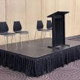 A podium with four chairs available for Lectern Hire.