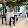 A table set up with black Tolix stools and flowers.