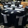 A black and silver banquet table adorned with elegant silver bows.