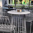 White table and chairs in an outdoor setting available for white wire cocktail table hire.