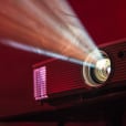 A 2500 Lumens digital projector with a red light shining on it available for hire.