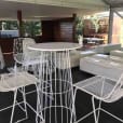 A white table and chairs in an outdoor setting for hire.