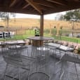 A patio with a view of a pond, featuring a table and chairs.