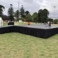 A grassy area transformed into a stage, complete with microphone stand hire.