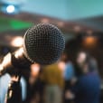 A wireless microphone in front of a crowd of people.