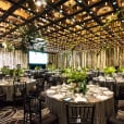 A large room with tables and chairs set up for an event, including Black Tiffany Chair Hire.