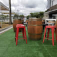 A group of red Tolix stools on a grassy area.