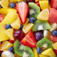 A vibrant display of medium-sized fruit platter, showcasing in-season fruits, presented in a bowl.
