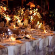 A dinner table set up with candles, flowers, and Victorian Ghost Chair Hire.