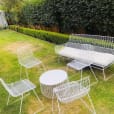 A white patio set with a table and chairs available for hire.