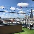 A rooftop deck adorned with festoon lights, providing a stunning view of the city.