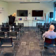 A group of people in conference chairs in a conference room.