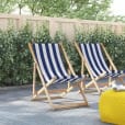 Two deck chairs on a patio with a deck chair hire yellow ottoman.