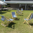 Deck chair hire: A row of blue and white deck chairs on a grassy area available for hire.