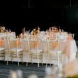 A wedding reception with gold tables and chairs.