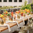 A table set with gold flowers on a rooftop.