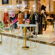 A gold table and chairs in a shopping mall available for Gold Wire Stool / Arrow Stool Hire.