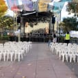 A stage set up with white plastic stackable chairs and banners.