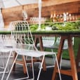 A white table and chairs with green grass in the background.