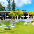 A large lawn with white tables and chairs available for White Chair Hire.