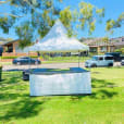 A fete stall/tent hire (including setup) in a grassy area.