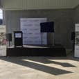 A lectern hire stage set up in front of a large warehouse.