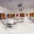 A spacious room with tables and chairs in it, where you can hire black wire coffee tables.