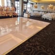 A glossy white dance floor is set up for a bridal wedding.