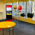 An office with red and yellow balloons and tables adorned with gold wire arrow table with marble top hire.