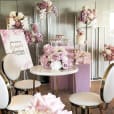 A pink bridal shower set up in a room, featuring the hire of three square plinths in a coordinating white color for added elegance.