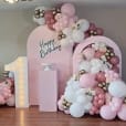 A pink balloon backdrop for a birthday party.
