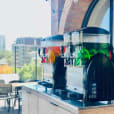 Two slushie machines on a balcony with a view of the city, offering package 5 for up to 240 drinks.