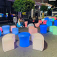 A group of colorful stools on a street at night, illuminated like a Glow Bench.