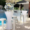 A pool party with white stools and chairs, featuring a Glow Cocktail Bar Table Hire.