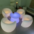 A set of white chairs and a table in a room available for Glow Couch Hire.