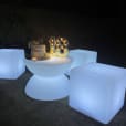 Three large white cubes sitting on a coffee table at night, emitting a gentle glow.